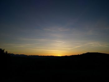 Scenic view of silhouette trees against sky at sunset