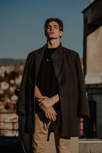 Full length of young man standing against sky