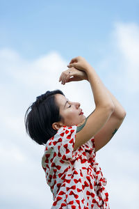 Low angle view of woman standing against sky