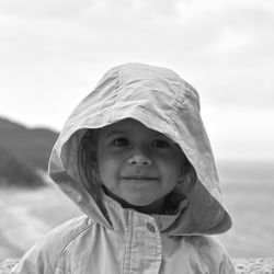 Portrait of girl wearing hood against sea