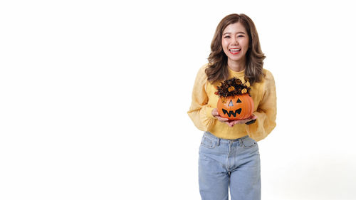 Portrait of a smiling young woman against white background