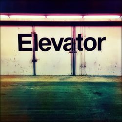 Elevator text on wall by road