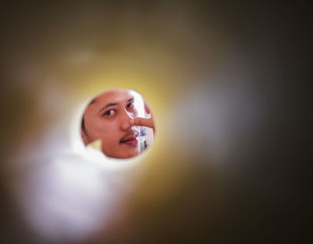 Portrait of man seen through rolled paper