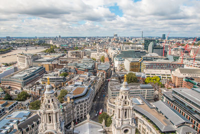 High angle view of city buildings against cloudy sky