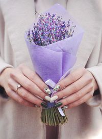 Close-up of hand holding purple flower bouquet