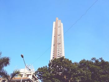 Low angle view of skyscraper against blue sky