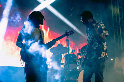 A guitar player and a bass player jamming at a concert