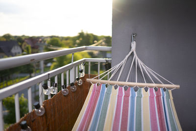 Close-up of clothes hanging on railing against sky