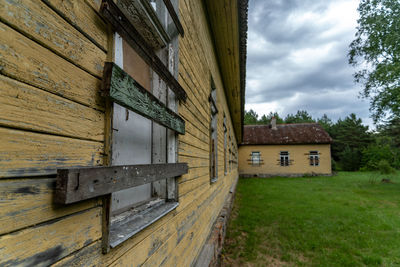 Exterior of old house on field against sky