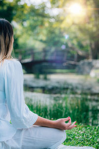 Meditation by the water. young woman meditating by the water, relaxation after yoga