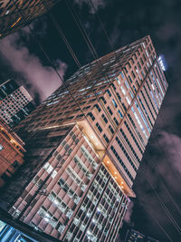 Low angle view of illuminated buildings against sky at night