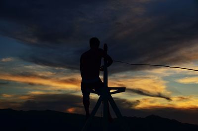 Silhouette man standing against sky during sunset