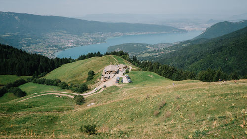 High angle view of green landscape and mountains against sky