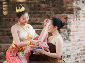 Young female models wearing traditional clothing against brick steps