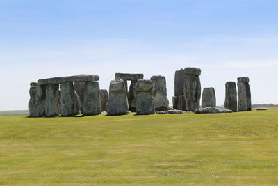 View of stonehenge with green meadow and blue sky on a sunny day in spring, united kingdom