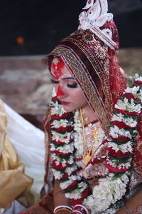 Bride in traditional clothing and floral garland during wedding