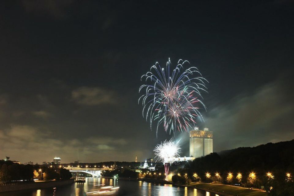 illuminated, night, firework display, exploding, long exposure, sky, celebration, arts culture and entertainment, firework - man made object, motion, architecture, built structure, glowing, building exterior, city, sparks, firework, water, blurred motion, multi colored