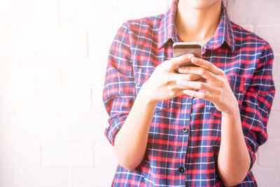 Midsection of woman holding mobile phone