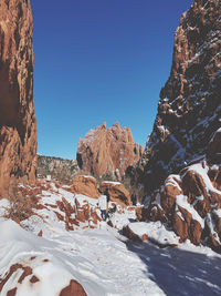 Rock formations against clear blue sky during winter