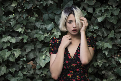 Portrait of woman standing against plants