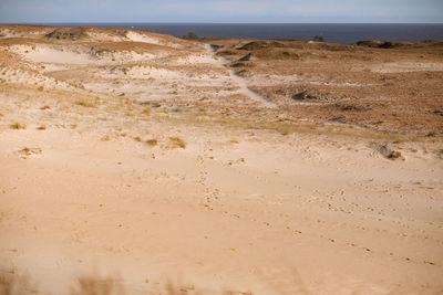 Scenic view of desert land against sky