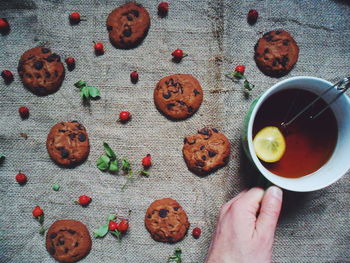 Chocolate oatmeal cookies and a cup of black tea with lemon on the table