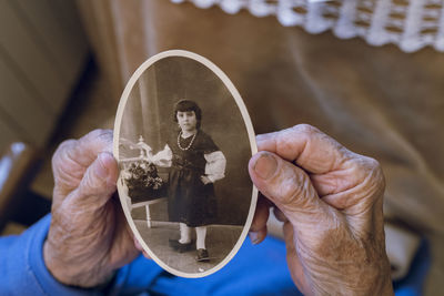 Senior woman with childhood photograph at home