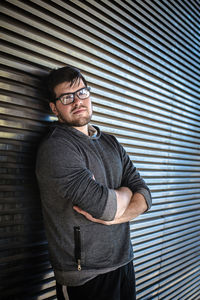 Young man standing against wall