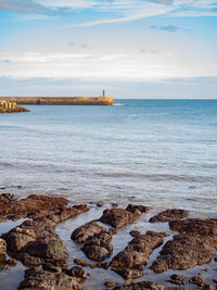 Lighthouse and breakwater on the horizon line
