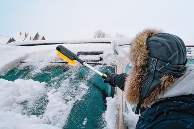 Rear view of man cleaning car