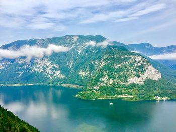 Scenic view of sea by mountains against sky