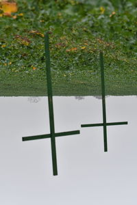 Cross on field against sky