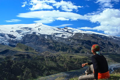 Man relaxing on mountain against eyjafjallajokull