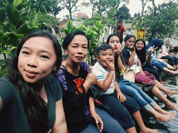 Portrait of smiling friends sitting outdoors