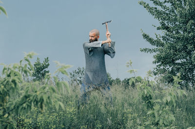 Emotional photo of medieval viking in metal chain mail swinging ax. historical photo concept.