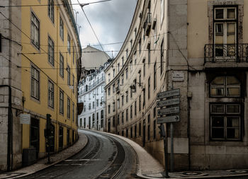 A slightly ascending road runs between the large houses of an old town