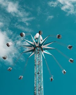 Low angle view of chain swing ride against sky