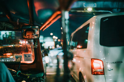 Cars on illuminated street seen through windshield