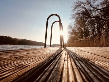 Surface level of wooden walkway against sky