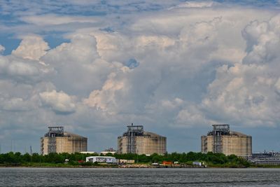 Buildings in city against cloudy sky