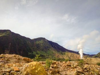 Smoke emitting from volcanic mountain against sky