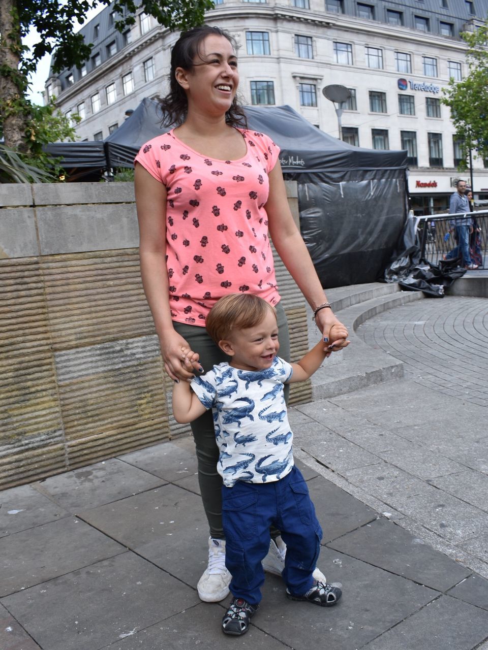 built structure, full length, togetherness, family with one child, architecture, day, building exterior, outdoors, mother, standing, love, childhood, city, real people, happiness, tree, young adult, young women, adult, people