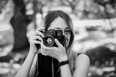 Portrait of woman photographing outdoors