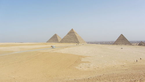 Scenic view of desert and pyramids against clear sky of cairo, egypt