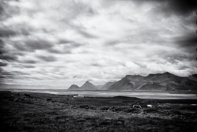 Scenic view of land and mountains against sky