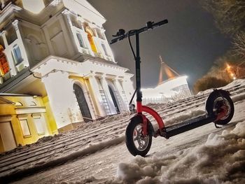 Bicycle parked on street against buildings in city