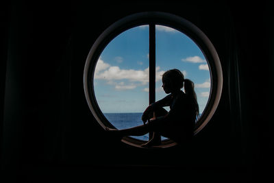 Rear view of man looking through window