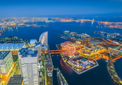 High angle view of illuminated cityscape against sky at night