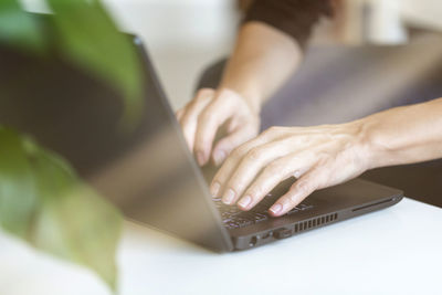 Young woman working from home, freelancer job concept, day light dynamic workplace.