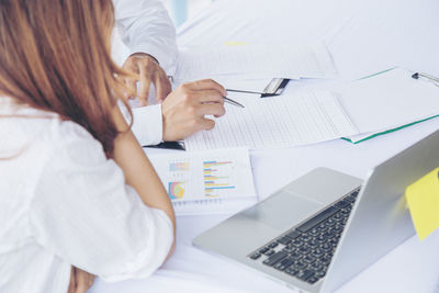Rear view of woman using laptop on table